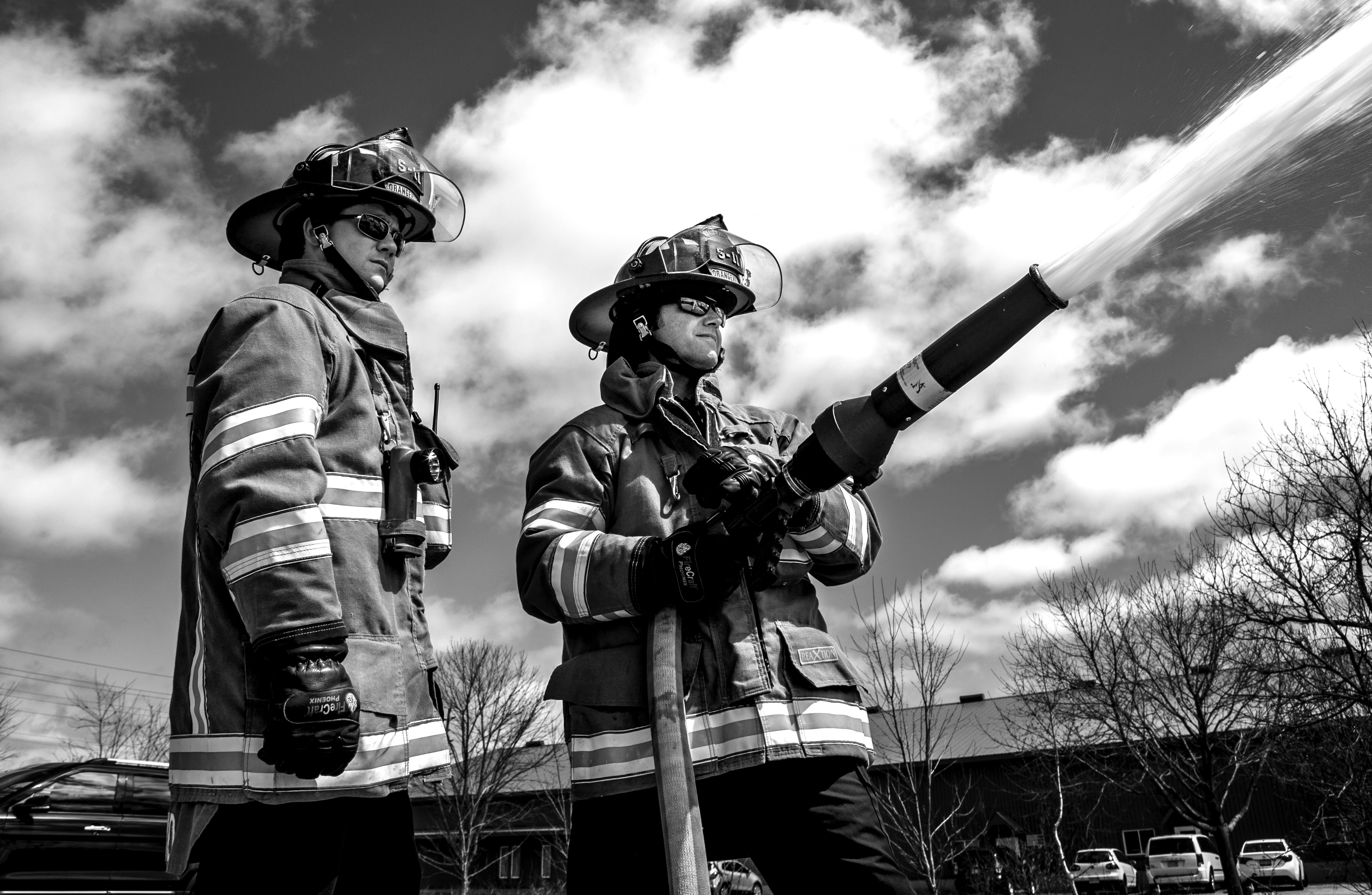 Two firefighters with a hose.